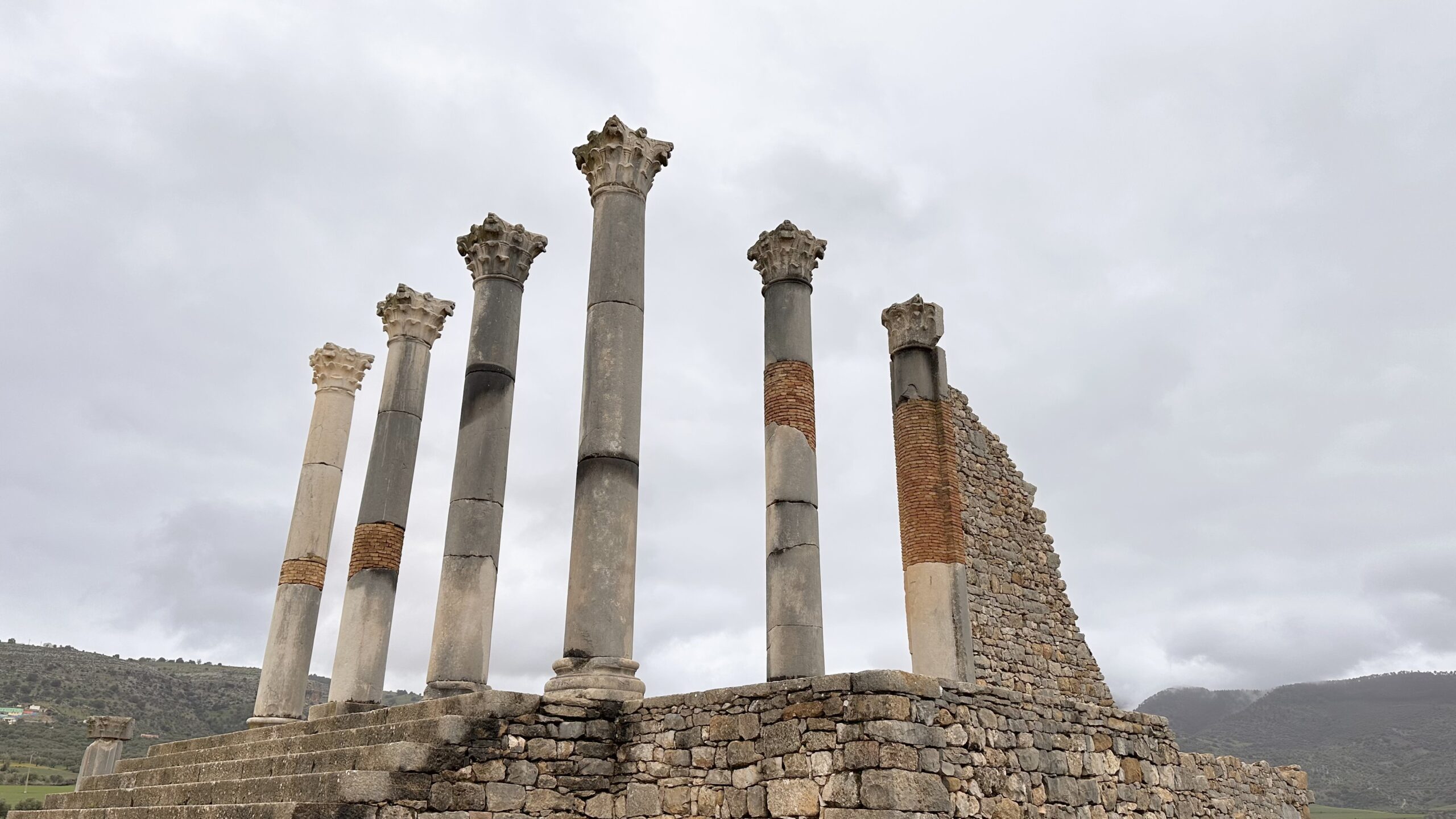 Die beeindruckenden Ruinen der römischen Stadt Volubilis, die majestätisch in der Landschaft liegen.